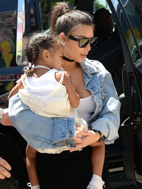Kim Kardashian carries North West out of church