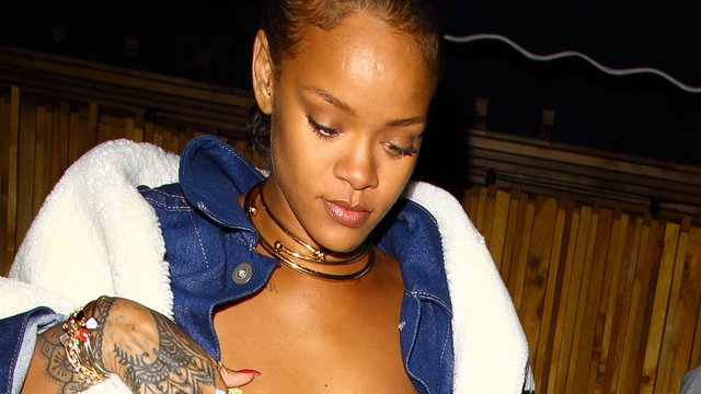 Rihanna readjusts her dress on a night out