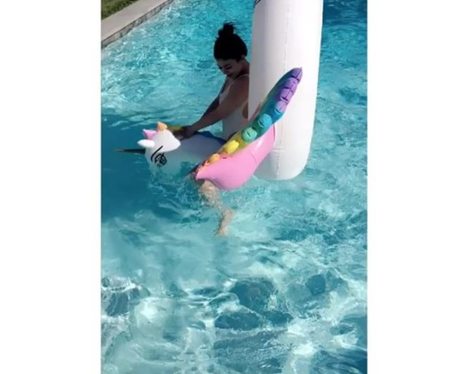 Kylie Jenner plays about in the pool