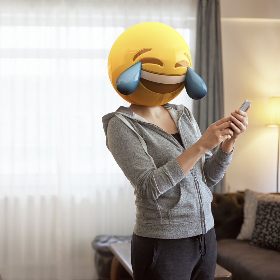 Woman wearing emoji masks while looking at her phone