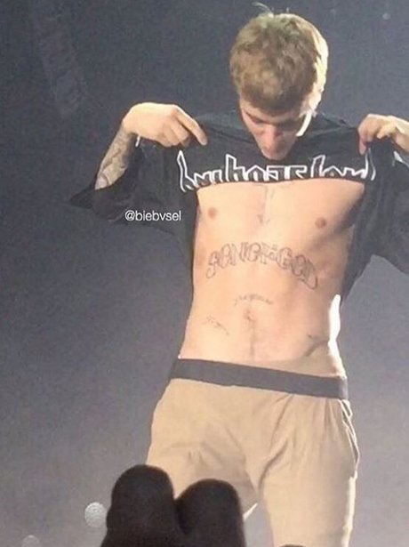 Justin Bieber shows off new tattoo on stage