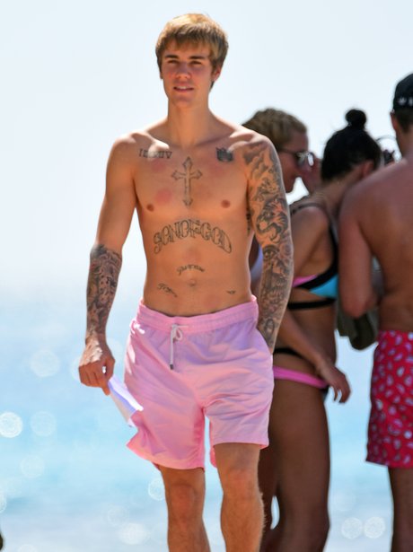 Justin Bieber shows off tattoo's and abs on the be