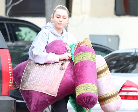 Miley Cyrus holding cushions
