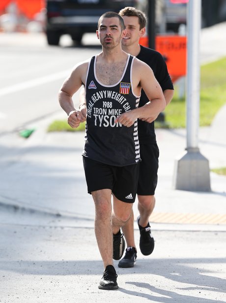 Joe Jonas shows off his muscles whilst out for a r