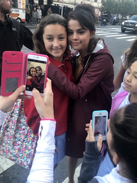 Selena Gomez crosses the road to get photos with f