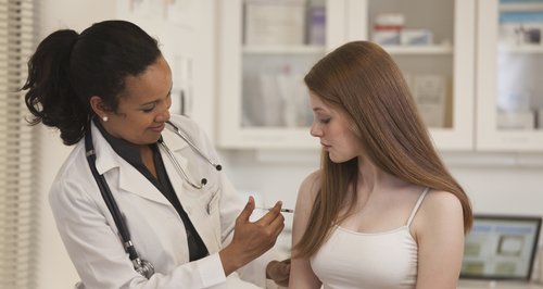 Doctor gives vaccine to girl